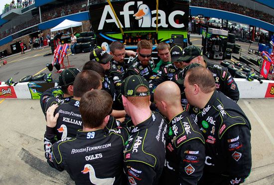 The No. 99 pit crew of Carl Edwards huddles before the start of the Heluva Good Sour Cream Dips 400 at Michigan International Speedway. (Credit: Tom Pennington/Getty Images)