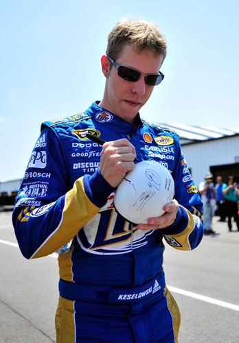 Brad Keselowski, driver of the No. 2 Miller Lite Dodge, signs an autograph in the garage area during practice for the 5-Hour Energy 500 at Pocono Raceway on June 10 in Long Pond, Pa. (Credit: Jason Smith/Getty Images)