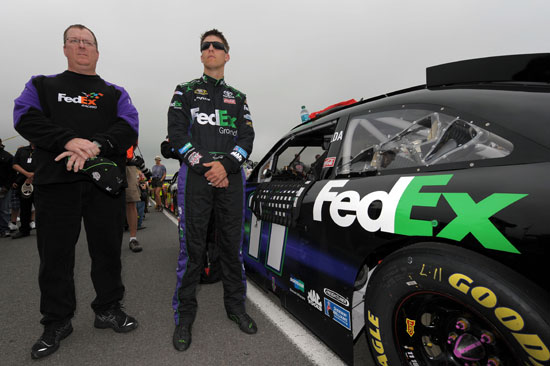 Denny Hamlin and crew chief Mike Ford stand by the No. 11 FedEx Toyota during pre-race activities for the 5-Hour Energy 500 at Pocono Raceway. (Credit: Drew Hallowell/Getty Images for NASCAR)
