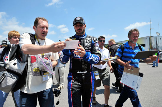 Jimmie Johnson, driver of the No. 48 Lowe's Chevrolet, signs an autograph during practice for the 5-Hour Energy 500 at Pocono Raceway on June 10 in Long Pond, Pa. (Credit: Jason Smith/Getty Images)