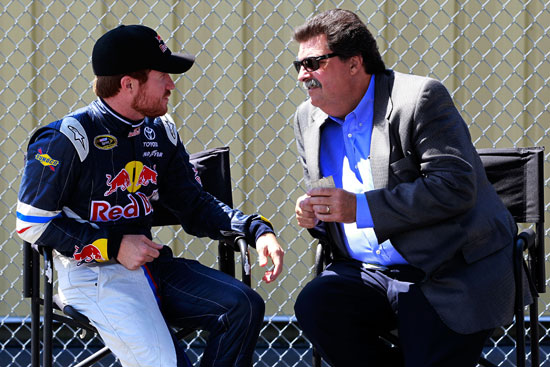 Brian Vickers (left), driver of the No. 83 Red Bull Toyota, talks with NASCAR President Mike Helton (right) in the garage during practice for the NASCAR Sprint Cup Series LENOX Industrial Tools 301 at New Hampshire Motor Speedway on July 15 in Loudon, N.H. (Credit: Chris Trotman/Getty Images)