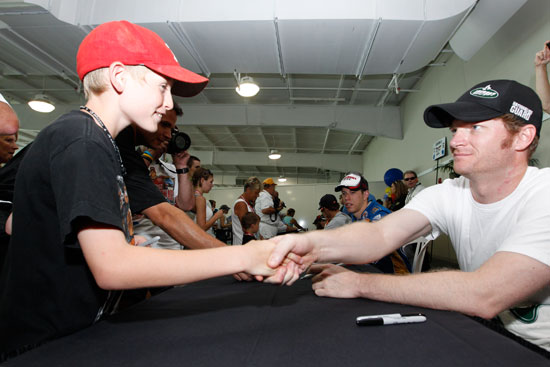 Dale Earnhardt Jr., driver of the No. 88 AMP Energy/National Guard Chevrolet, signs an autograph for a race fan at the largest 2011 NASCAR Sprint Cup Series autograph session held at Indianapolis Motor Speedway on July 30 in Indianapolis, Ind. (Credit: Getty Images for NASCAR)