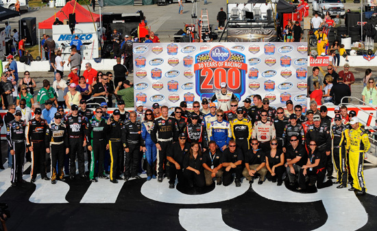 The starting lineup of drivers pose with the staff from Lucas Oil Raceway during pre-race activities for the NASCAR Nationwide Series Kroger 200 at Lucas Oil Raceway on July 30 in Indianapolis, Ind. (Credit: Jason Smith/Getty Images for NASCAR)