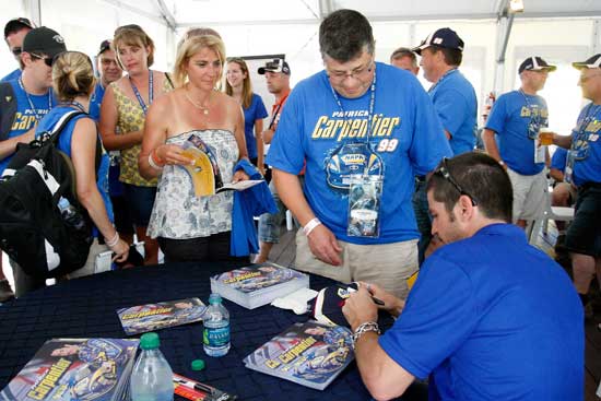 Patrick Carpentier of the No. 99 NAPA Auto Parts Toyota signs autographs for fans prior to the NAPA Auto Parts 200 at Circuit Gilles Villeneuve on Aug. 20 in Montreal, Quebec, Canada. (Credit: Richard Wolowicz/Getty Images)