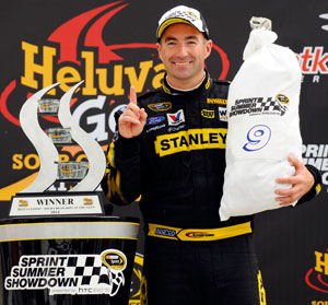 Marcos Ambrose, driver of the No. 9 Stanley Ford, poses in Victory Lane after winning the NASCAR Sprint Cup Series Heluva Good! Sour Cream Dips at the Glen at Watkins Glen International on Aug. 15 in Watkins Glen, N.Y. (Credit: Jason Smith/Getty Images for NASCAR)