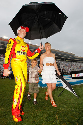 Kurt Busch, driver of the No. 22 Shell/Pennzoil Dodge, walks with his girlfriend, Patricia Driscoll, and her son, Houston, during driver introductions prior to the NASCAR Sprint Cup Series AdvoCare 500 at Atlanta Motor Speedway on Sept. 4 in Hampton, Ga. (Credit: Todd Warshaw/Getty Images)