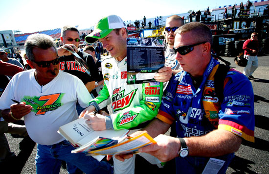 Dale Earnhardt Jr., driver of the No. 88 Diet Mountain Dew Chevrolet, signs autographs for fans during practice for the NASCAR Sprint Cup Series Good Sam Club 500 at Talladega Superspeedway on Oct. 21 in Talladega, Ala. (Credit: Jeff Zelevansky/Getty Images for NASCAR)