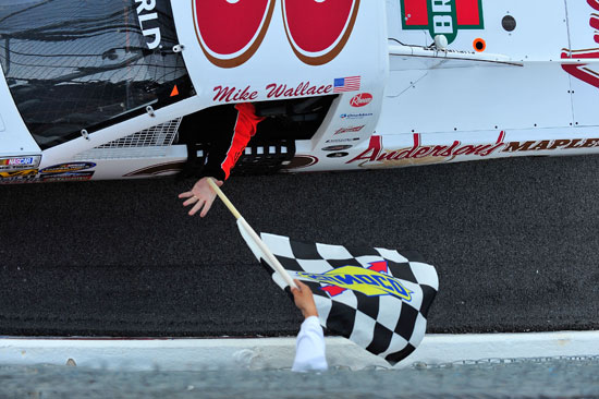 Mike Wallace receives the checkered flag after winning the Coca-Cola 250 at Talladega Superspeedway. (Credit: Jason Smith/Getty Images for NASCAR)