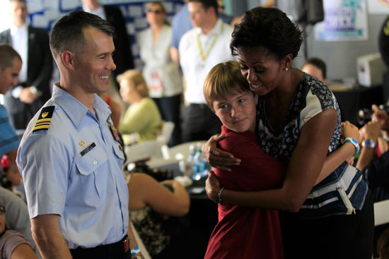 First Lady Michelle Obama hugs a child as she greets military families at a Joining Forces pre-race event at Homestead-Miami Speedway on Sunday, Nov. 20. (Credit: By Chris Trotman, Getty Images for NASCAR)