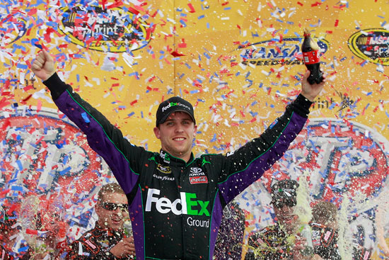 Denny Hamlin celebrates his 19th career NASCAR Sprint Cup Series win in Kansas Speedway's Victory Lane on Sunday in Kansas City, Kan. (Credit: Chris Graythen/Getty Images for NASCAR)