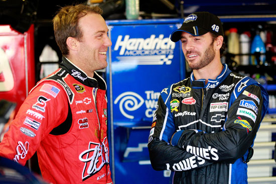 Kevin Harvick, driver of the No. 29 Budweiser Folds of Honor Chevrolet, talks to Jimmie Johnson, driver of the No. 48 Lowe's Chevrolet, in the garage area during practice for the NASCAR Sprint Cup Series Series Quicken Loans 400 at Michigan International Speedway on Friday in Brooklyn, Mich. (Credit: Geoff Burke/Getty Images for NASCAR)