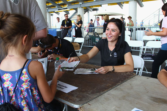 Natalie Sather signs an autograph for a fan before the American Ethanol 200 at Iowa Speedway. (Credit: Dilip Vishwanat/Getty Images)