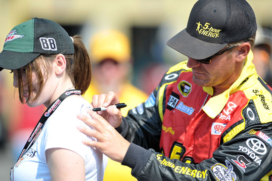 Clint Bowyer signs an autograph during qualifying for the LENOX Industrial Tools 301 at New Hampshire Motor Speedway. (Credit: Drew Hallowell/Getty Images for NASCAR)